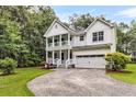 Beautiful two-story home with a double porch, a two-car garage, and a well-manicured front lawn and rock driveway at 2226 Arthur Rose Ln, Johns Island, SC 29455