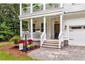 Inviting front porch with white railings, flower boxes, and a cozy seating area leading to the front door at 2226 Arthur Rose Ln, Johns Island, SC 29455