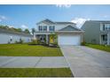 Beautiful two-story home boasts a yellow front door, manicured lawn, and a two-car garage at 225 N Light Way, Summerville, SC 29486