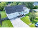 Charming single-story home with an attached garage and a cozy front porch, surrounded by lush greenery at 229 Lindy Creek Rd, Goose Creek, SC 29445