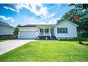Inviting single-story home featuring a cozy front porch, an attached garage, and a well-maintained lawn at 229 Lindy Creek Rd, Goose Creek, SC 29445