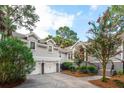 View of the home's exterior with the two car garage, steps to the front door and landscaped yard at 2645 Gnarled Pine, Seabrook Island, SC 29455