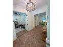 Elegant foyer with brick floors, contemporary lighting, and views into the office and living spaces at 2725 Starfish Dr, Johns Island, SC 29455