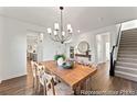 Elegant dining room with hardwood floors, a stylish chandelier, and staircase access at 279 Surf Bird Rd # 465, Summerville, SC 29486