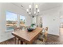 Bright dining area featuring a wooden table, modern lighting, and large windows at 279 Surf Bird Rd # 465, Summerville, SC 29486