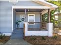Inviting front porch with a gray floor, wood pillars, brick base, and a stylish wreath at 2924 Chicora Ave, North Charleston, SC 29405