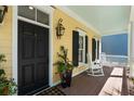 Inviting front porch with a black door, rocking chairs and stylish décor at 316 Bridgetown Pass, Mount Pleasant, SC 29464