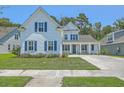 Inviting two-story home with white siding, blue shutters, well-manicured lawn, and a welcoming driveway at 420 Oak View Way, Summerville, SC 29483