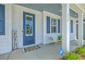 Cozy front porch with a blue door, ADT security sign, and a charming welcome mat and seating at 420 Oak View Way, Summerville, SC 29483