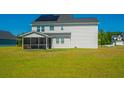 Backyard view features a screened in porch and solar panels on a two-story house at 6976 Pumpkinseed Dr, Johns Island, SC 29455
