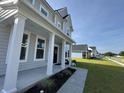 Inviting front porch with classic white columns and manicured landscaping by the front door at 6976 Pumpkinseed Dr, Johns Island, SC 29455