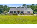 Well-maintained one story home with mature landscaping, light colored siding, stone veneer and large front yard at 708 Tierra Loop, Summerville, SC 29483