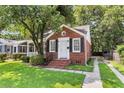 Charming brick home with manicured lawn, classic architectural details, and paved driveway at 727 Savannah Hwy, Charleston, SC 29407