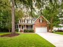 Inviting home with a blend of brick and siding, a two-car garage, and lush green landscaping at 8316 Dye Makers, North Charleston, SC 29418