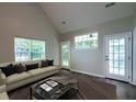Bright living room features vaulted ceilings, modern furnishings, large windows, and rich wood floors at 8721 Grassy Oak Trl, North Charleston, SC 29420
