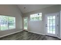 Bright living room with vaulted ceilings, large windows, and French doors to the exterior at 8721 Grassy Oak Trl, North Charleston, SC 29420