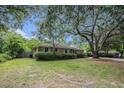 Ranch home featuring a large tree, shutters, and a well-maintained lawn at 943 Mikell Dr, Charleston, SC 29412