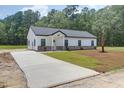 Beautifully built home displays a contemporary exterior, a long driveway, and a well-maintained lawn with green grass at 112 Southsong Ln, Goose Creek, SC 29445