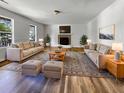 Spacious living room featuring neutral sofas, ottomans, fireplace, large windows, and stylish rug at 120 Apache Dr, Summerville, SC 29483