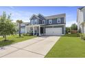 Inviting two-story home featuring blue siding, a two-car garage, and a cozy front porch with ample driveway space at 120 Haverhill St, Summerville, SC 29486