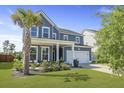 Beautiful two-story home with blue siding, a two-car garage, a cozy front porch and lush green lawn at 120 Haverhill St, Summerville, SC 29486