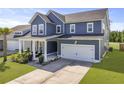 Attractive two-story home with blue siding, a two-car garage, and a charming front porch with outdoor seating at 120 Haverhill St, Summerville, SC 29486