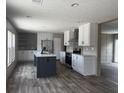 Modern kitchen with white cabinets, stainless steel appliances, kitchen island, and hardwood floors that offer modern appeal at 1420 Rehoboth Rd, Cottageville, SC 29435