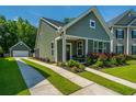Charming home with a well-manicured lawn, colorful flowerbeds, and a convenient detached garage at 1607 Roustabout Way, Charleston, SC 29414