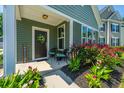Inviting front porch with chairs, colorful flowers, and a welcoming 'Welcome' sign at 1607 Roustabout Way, Charleston, SC 29414