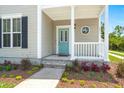 Inviting front porch features a teal door, charming round window, and well-maintained landscaping at 1844 Hubbell Dr, Mount Pleasant, SC 29466