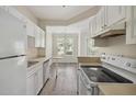 Functional kitchen features white appliances, ample cabinetry, and sleek wood flooring, ideal for cooking at 1915 Chatelain Way, Mount Pleasant, SC 29464