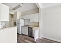 Compact kitchen with white cabinets, stainless steel dishwasher, and wooden floors at 1915 Chatelain Way, Mount Pleasant, SC 29464