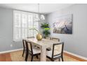 Chic dining area with stylish chandelier, shuttered windows, and seating for six guests at 2009 Arundel Pl, Mount Pleasant, SC 29464