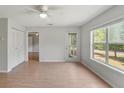 Sunlit living room features wood-look floors, a ceiling fan, large window, and balcony access at 2011 N Highway 17 # 1400P, Mount Pleasant, SC 29466