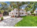 Stunning exterior with double porches and lush green lawn, offering a tranquil and picturesque setting at 2021 Lakeshore Dr, Charleston, SC 29412