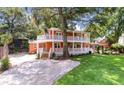 Beautiful exterior view showcases the home's double porch and manicured lawn, perfect for outdoor enjoyment at 2021 Lakeshore Dr, Charleston, SC 29412