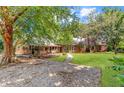 Expansive property with a lush lawn, mature trees, and a welcoming gravel driveway, ideal for outdoor living at 2021 Lakeshore Dr, Charleston, SC 29412