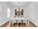 Elegant dining room with hardwood floors, a white dining set, and a decorative chandelier fixture at 3020 River Vista Way, Mount Pleasant, SC 29466