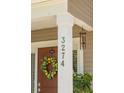 Inviting front porch with address numbers, a lemon wreath on the door, and decorative accents at 3274 Arrow Arum Dr, Johns Island, SC 29455