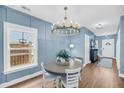 Cozy dining room with a round table, white chairs, and a modern chandelier at 331 Saddlewood Dr, Charleston, SC 29414