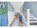 Light and bright foyer with blue walls, wood floors, and a staircase with black iron spindles at 331 Saddlewood Dr, Charleston, SC 29414