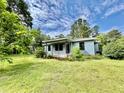 Inviting front yard with green grass surrounding a cozy home, landscaped with flowering bushes and plants at 365 W Pine St, Varnville, SC 29944
