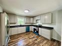 Modern kitchen featuring grey cabinets, sleek black countertops, new stainless steel appliances, and wood-look flooring at 365 W Pine St, Varnville, SC 29944