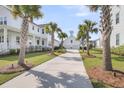 Long driveway leads to a lovely two-story home with a detached garage surrounded by palm trees at 3769 Summerton St, Mount Pleasant, SC 29466