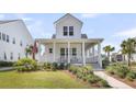 Inviting two-story home features a spacious front porch, well-manicured lawn, and classic white facade at 3769 Summerton St, Mount Pleasant, SC 29466