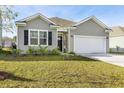 Charming single-story home featuring a well-manicured lawn and attached two car garage at 5000 Paddy Field Way, Ladson, SC 29456