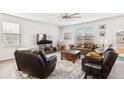 Bright living room featuring plush seating, large windows, and modern ceiling fan at 5000 Paddy Field Way, Ladson, SC 29456