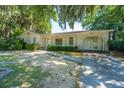 Charming one-story brick home with attached carport, lush landscaping, and mature trees at 5302 Helene Dr, North Charleston, SC 29418