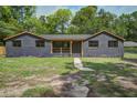 Traditional home with a brick facade, green lawn and mature trees at 670 Dupre Rd, McClellanville, SC 29458