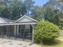 Exterior shot of gray home with black trim, a cozy front porch, and a well-manicured yard at 687 Ponderosa Dr, Charleston, SC 29414